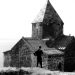 A black and white photo of a man standing in front of a church